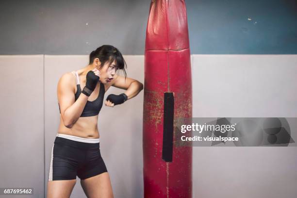 girl in martial arts practice, punching bag - toughness stock pictures, royalty-free photos & images