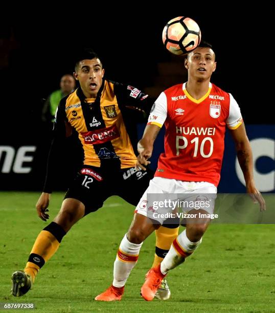 Juan Roa of Independiente Santa Fe fights for the ball with Agustin Jara of The Strongest during a match between Independiente Santa Fe and The...