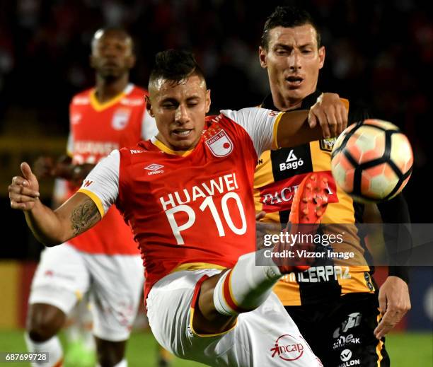 Juan Roa of Independiente Santa Fe fights for the ball with Pablo Escobar of The Strongest during a match between Independiente Santa Fe and The...
