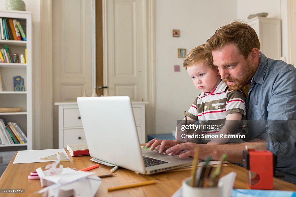 Professional with toddler son working at home
