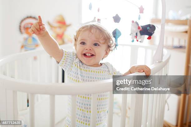 a 15 months old boy in his baby's crib - chambre bébé photos et images de collection