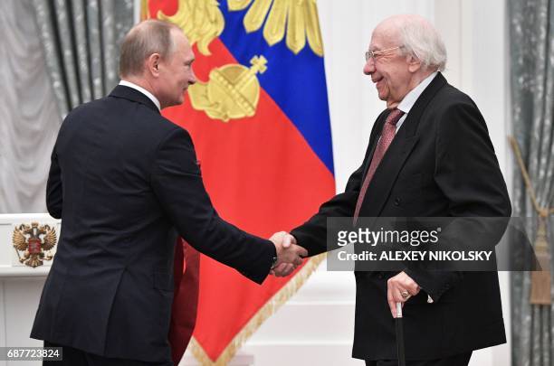 Russian President Vladimir Putin awards Russian musician Gennady Rozhdestvensky during a ceremony at the Kremlin in Moscow on May 24, 2017. / AFP...