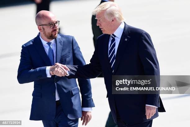 President Donald Trump shakes hands with Belgian Prime Minister Charles Michel upon arrival at the Melsbroek military airport in Steenokkerzeel on...