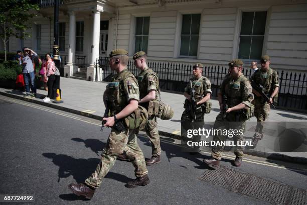 British Army soldiers are led by a police officer into Buckingham Palace in central London on May 24, 2017. Britain deployed soldiers to key sites...