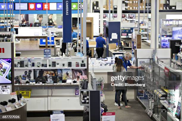 An employee assists customers at a Best Buy Co. Store in Downers Grove, Illinois, U.S., on Tuesday, May 23, 2017. Best Buy Co. Is scheduled to...