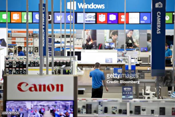 An employee stands near Canon Inc. Signage at a Best Buy Co. Store in Downers Grove, Illinois, U.S., on Tuesday, May 23, 2017. Best Buy Co. Is...