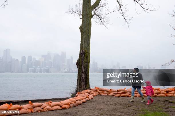 Woman and a child walk along the shore of Wards Island. Toronto Mayor John Tory visited the Wards Island to see the flooding efforts and water levels.