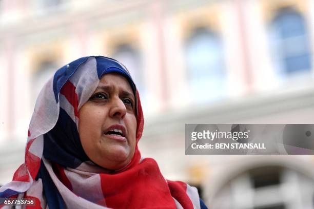 British-Pakistani woman, wearing a Union flag themed headscarf, pays her respects near the floral tributes left in St Ann's Square in Manchester,...