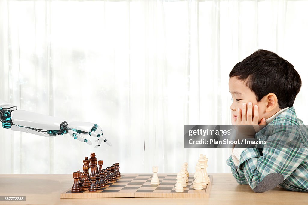 A child and AI robot arm playing chess