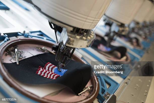 Rows of embroidery machines stitch an American flag design onto baseball hats at the Graffiti Caps production facility in Cleveland, Ohio, U.S., on...