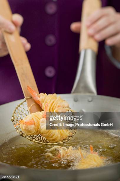 deep-frying noodle-wrapped prawns in wok - straining spoon stock pictures, royalty-free photos & images