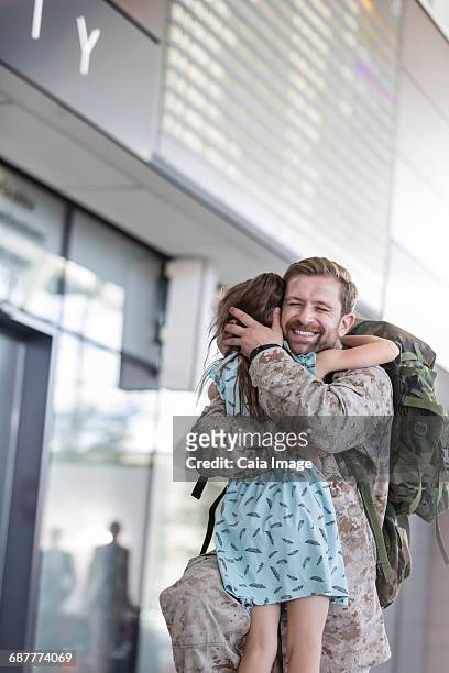 daughter greeting and hugging soldier father at airport - leanintogether stock pictures, royalty-free photos & images