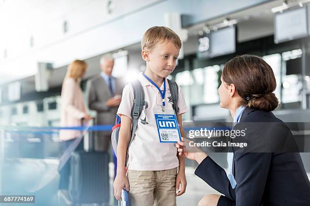 flight attendant talking to child traveler in airport - airport crew stock pictures, royalty-free photos & images