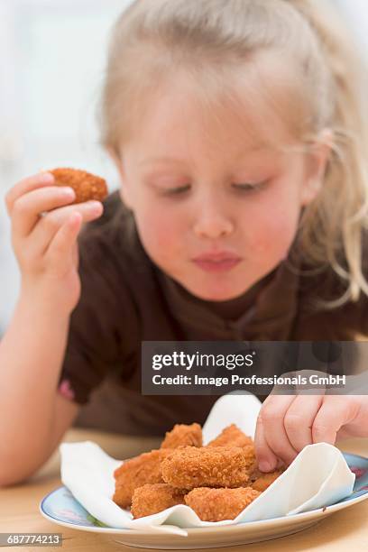 little girl eating chicken nuggets - eating nuggets stockfoto's en -beelden