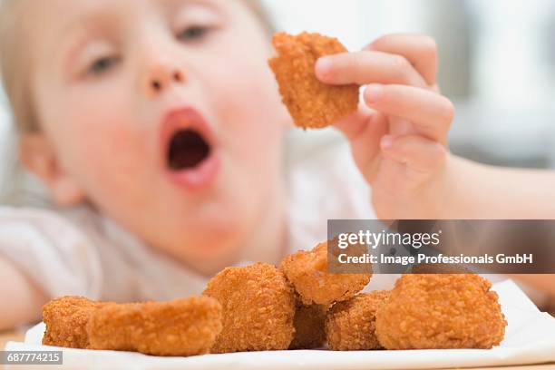 little girl eating chicken nuggets - chicken nugget photos et images de collection