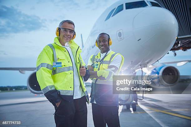 portrait confident air traffic control ground crew workers near airplane on airport tarmac - airport ground crew stock pictures, royalty-free photos & images