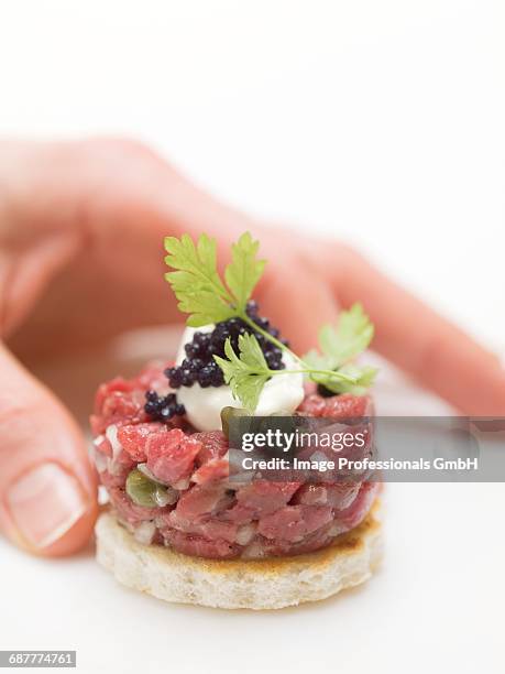 hand reaching for tuna tartare canap_ - canap�� stock-fotos und bilder