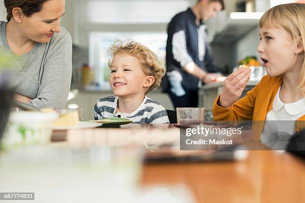 happy family eating breakfast at home - dining table stock-fotos und bilder