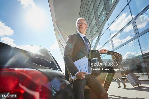 businessman arriving at airport getting out of town car - car arrival stock pictures, royalty-free photos & images
