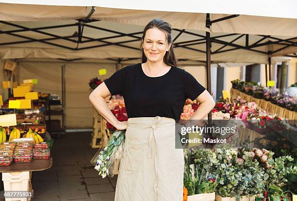 portrait of confident female owner standing at flower shop - market stall stock pictures, royalty-free photos & images