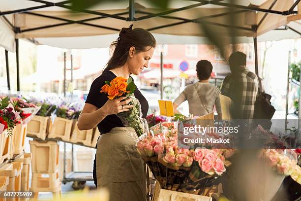 side view of female owner working at flower shop - puesto de mercado fotografías e imágenes de stock