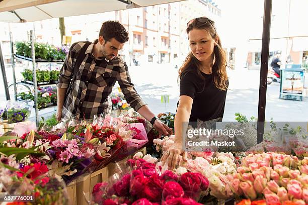 couple choosing flowers at market - flower market woman stock pictures, royalty-free photos & images
