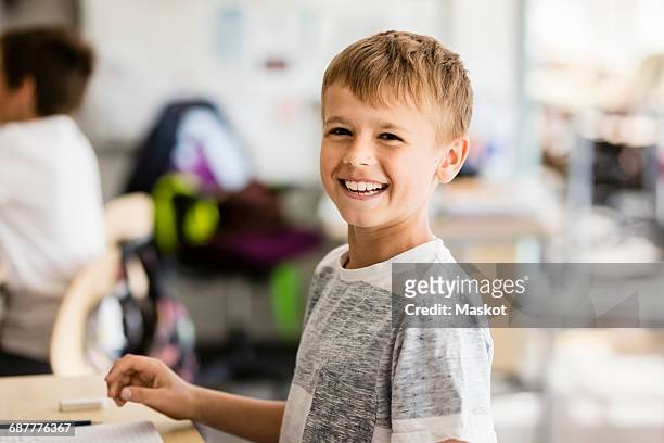 portrait of happy boy in classroom at school - tweenies stockfoto's en -beelden