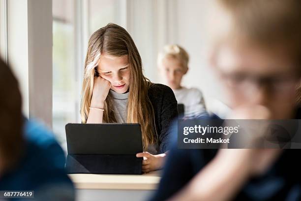 girl reading from digital tablet for learning in classroom - school teacher light stock pictures, royalty-free photos & images