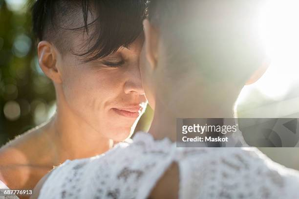 Close-up of newlywed lesbian couple embracing outdoors