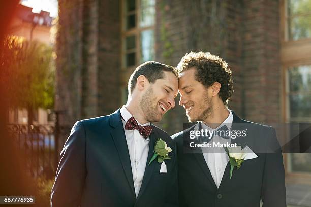 happy newlywed gay couple standing outdoors - gay marriage stock pictures, royalty-free photos & images