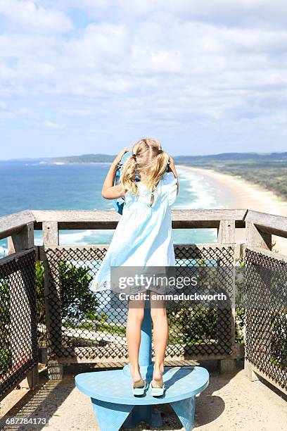 girl looking through coin operated binoculars - viewfinder stock pictures, royalty-free photos & images