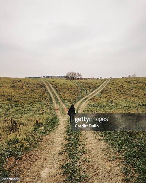 woman standing at a crossroads - 分かれ道 ストックフォトと画像