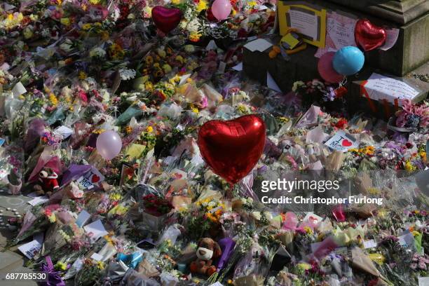 People begin to gather around floral tributes to the victims of the Manchester attack ahead of ahead of a vigil by religous leaders from across...