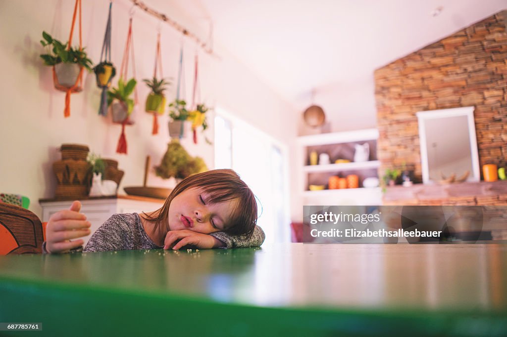 Girl sleeping at kitchen table