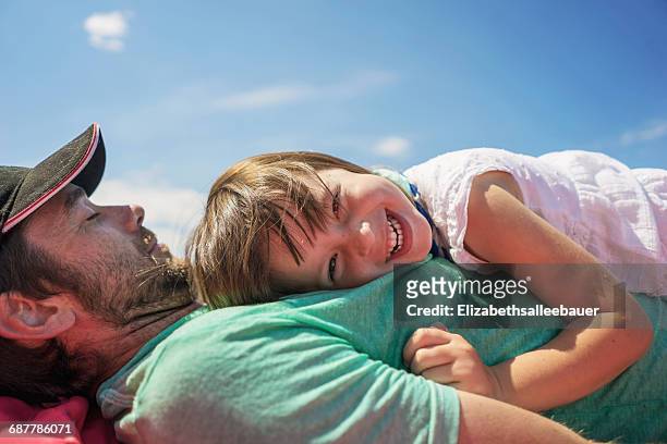 Smiling girl lying on her father's chest