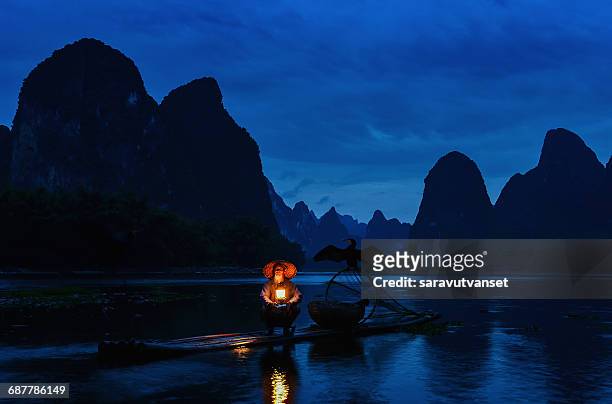 fisherman  on raft on li river at night, guilin, guangxi,  china - naturwunder stock-fotos und bilder
