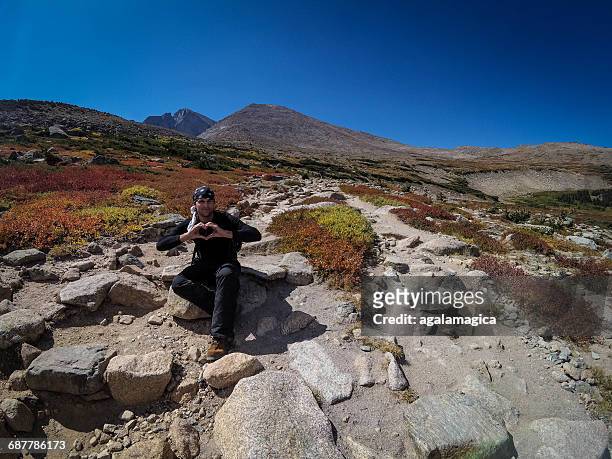 man holding his hands in a heart shape, longs peak, colorado, america, usa - front range mountain range fotografías e imágenes de stock