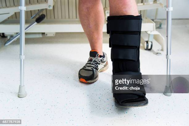 muscular athlete with walking boot for achilles tendon treatment - surgical footwear stock pictures, royalty-free photos & images