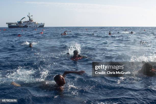 Refugees and migrants are seen swimming and yelling for assitance from crewmembers from the Migrant Offshore Aid Station 'Phoenix' vessel after a...