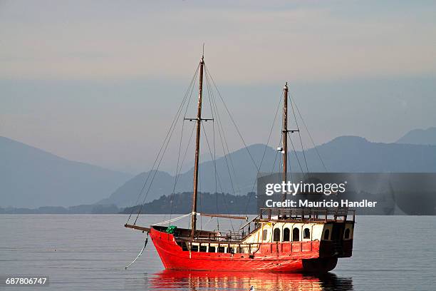 a sailing vessel lies at anchor on llanquihue lake, puerto varas, chile. - llanquihue lake stock pictures, royalty-free photos & images