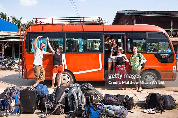 backpackers wait for their tour bus to depart. - dubbeldekker bus stockfoto's en -beelden