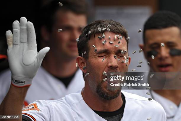 Hardy of the Baltimore Orioles has sunflower seeds thrown on him as he celebrates in the dugout with teammates after hitting a home run against the...
