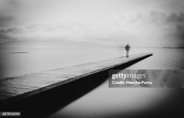 figure of man walking on a wooden walkway in the sea - suicidio fotografías e imágenes de stock