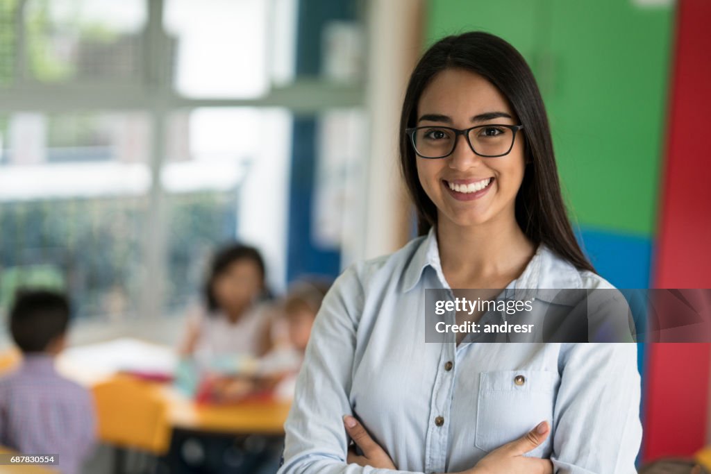 Portrait of a happy Latin American teacher at the school