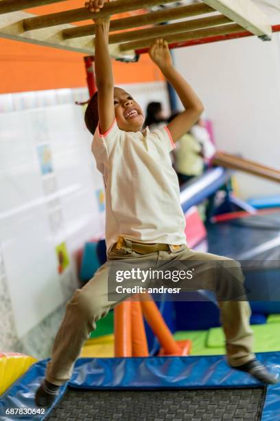 happy boy playing at the park on the monkey bars - boy on monkey bars stock pictures, royalty-free photos & images