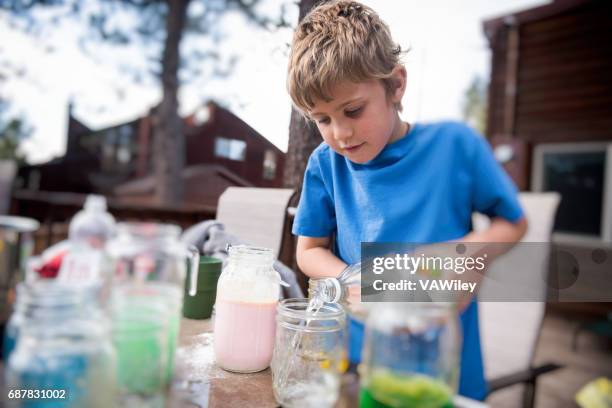 child adding chemicals to an experiment - water beaker stock pictures, royalty-free photos & images