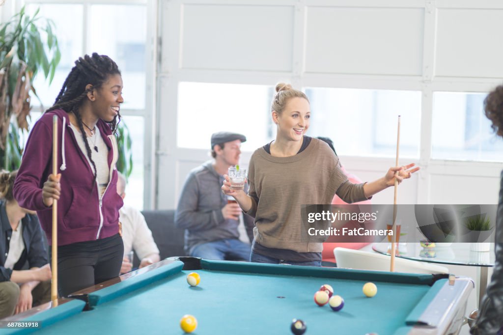 Friends hang out and play some pool together