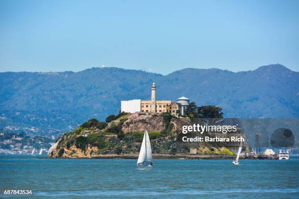 alcatraz island across the san francisco bay with sailboats on a beautiful spring day - alcatraz island stock pictures, royalty-free photos & images