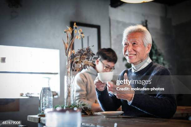 gelukkige senior eigenaar ontspannen in het café - オーナー stockfoto's en -beelden