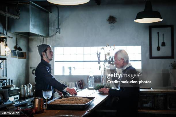 gesprek met een andere generatie in café - 働く stockfoto's en -beelden